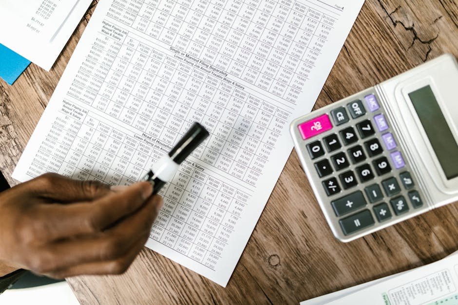 Calculator and laptop on a desk used for working out matched betting lay stakes