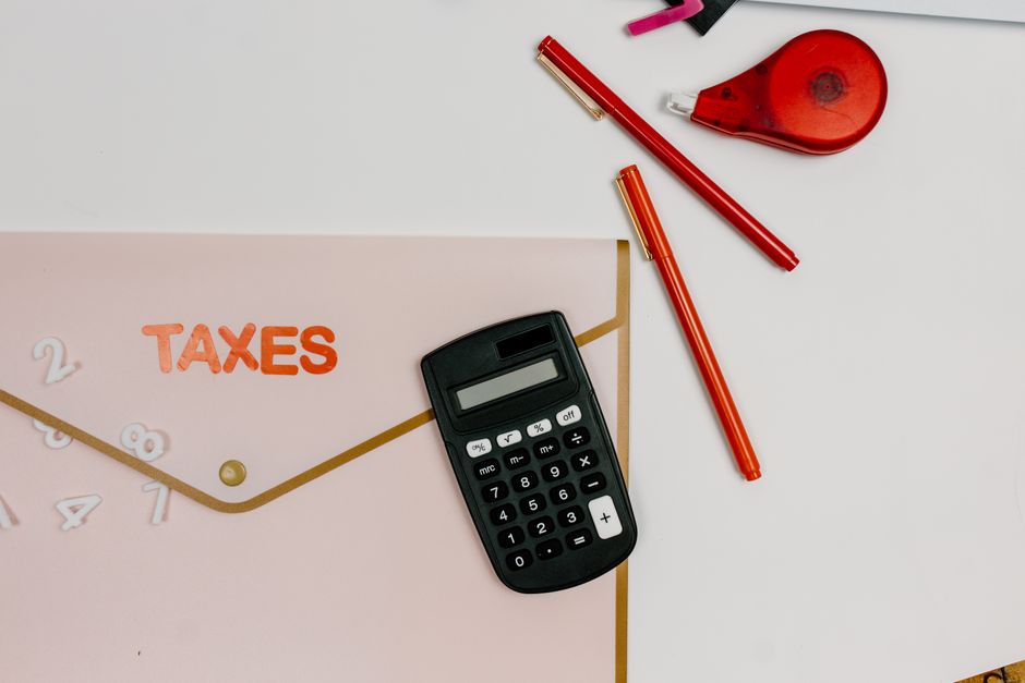 Flat lay calculator, pens and TAXES folder representing UK matched-betting tax position